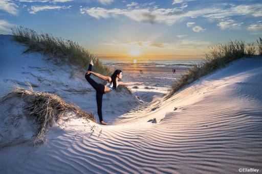 Wanddeko Yoga Asana der Taenzer am Meer magische Yogapraxis mit Sonne in Duenenlandschaft